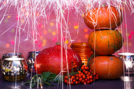 感恩节和万圣节的南瓜和蜡烛组成。橙色背景, 色调, 散景, 灯, 蜡烛。秋季礼品