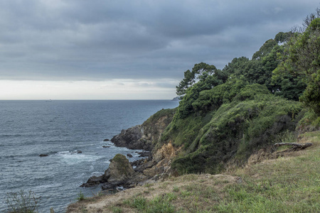 蓝色海的美丽的风景打破波浪在岩石与云彩