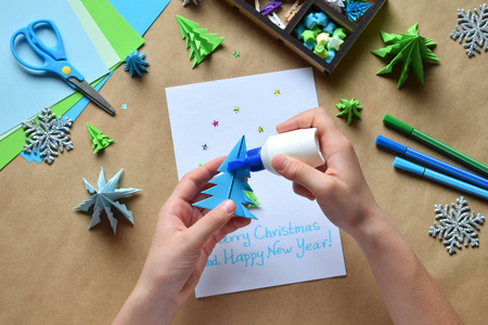 制作贺卡与折纸3d 圣诞树从纸。圣诞快乐, 新年装饰愉快。儿童 Diy 的概念。手工工艺品在假日用您自己的手