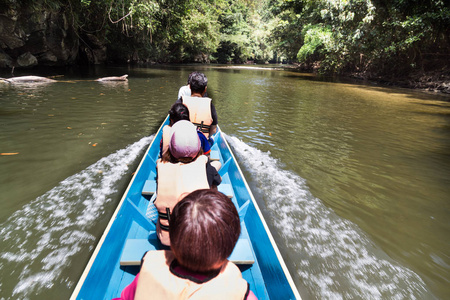 Merlinau 河上的游客乘坐长船到姆鲁国家公园的风和清水洞穴