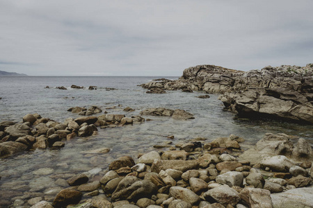 蓝色海的美丽的风景打破波浪在岩石与云彩