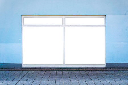 街道上蓝色墙上的白色修剪窗户。修剪区域将替换现有的广告。商业和广告概念