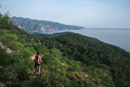 山中徒步旅行。一个女孩站在高山的背景下。那个女孩正在休息