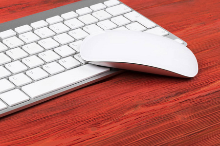 密切联系无线电脑键盘按键和鼠标上旧的红色天然木桌背景视图的业务工作场所。办公室的桌上副本空间
