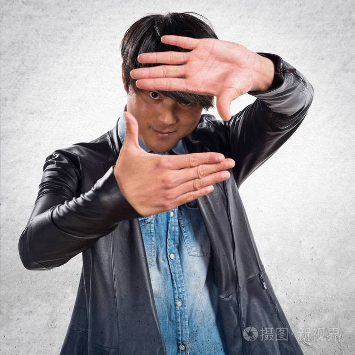 亚洲英俊的男人用他的手指专注于纹理背景