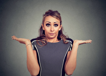 确定的答案年轻女子已耸耸肩膀看着相机没有答案照片