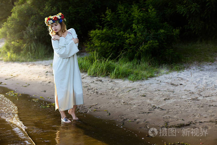 在与花圈庆祝民族服装的女孩