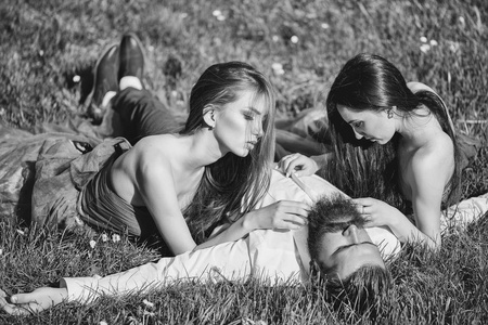 大胡子和两个妇女在草地上