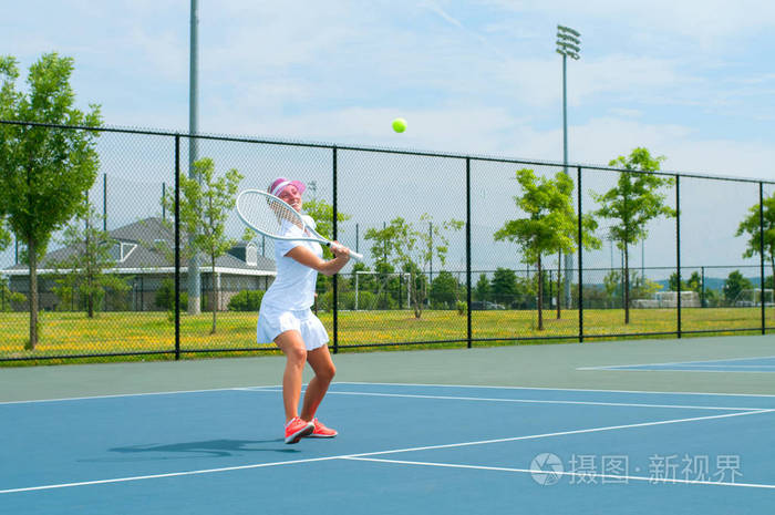 年轻女子在网球场上打网球