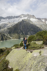 徒步旅行者徒步穿越冰川湖与野生高高山风景