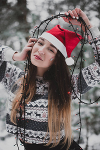 冬天的年轻美丽的黑发女人，穿了件毛衣的画像。下雪的冬天美容时尚概念