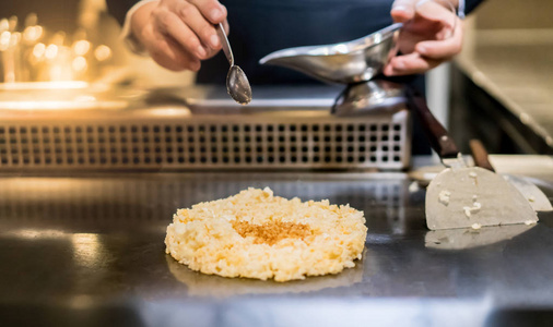 手的厨师烹饪大蒜炒米饭热平底锅在铜上