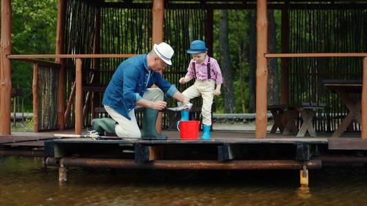 小男孩和他的爷爷在湖淡水捕鱼捕鲑鱼
