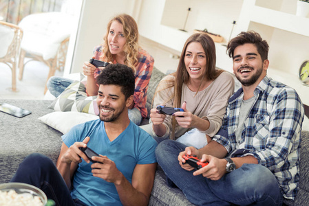 在数字平板电脑上玩游戏年轻女子一起玩游戏与外行娃娃在桌上与咖啡杯