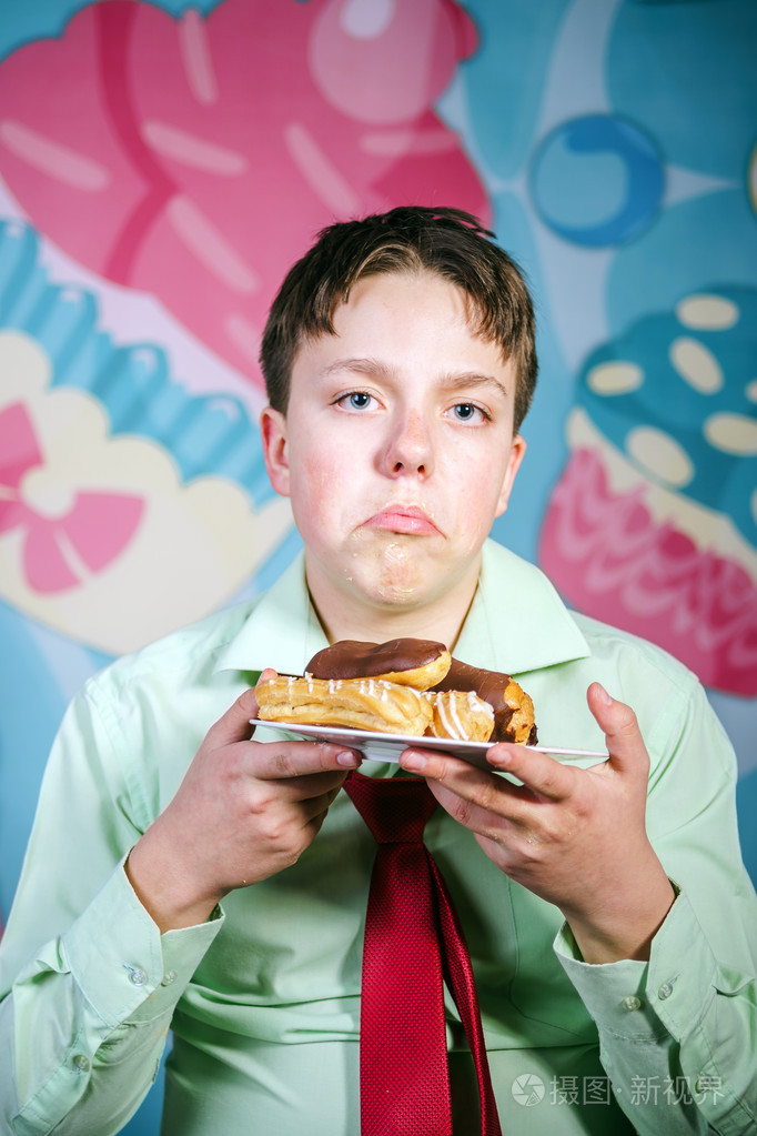 滑稽的男孩甜吃蛋糕,饥饿和糖果人