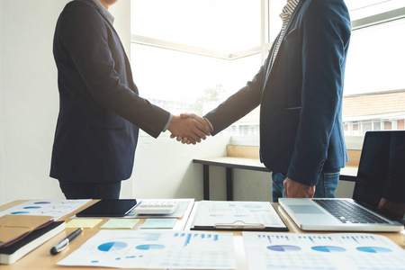 两个同事签署一项合同,商务会议在办公室业务团队在会议结束后握手