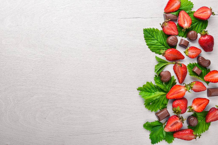 新鲜草莓和巧克力。健康的食物。木制的背景。顶视图。可用空间