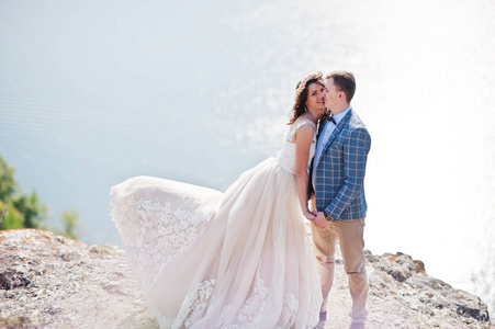 漂亮的新娘和新郎亲吻与悬崖边上