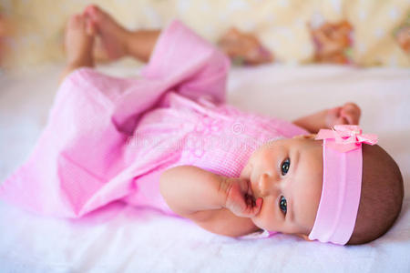 穿粉红色连衣裙的有趣女婴