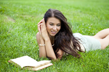 美丽的年轻女子在户外看书