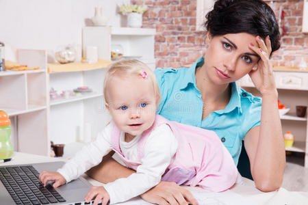 带笔记本电脑的女商人和她的女婴