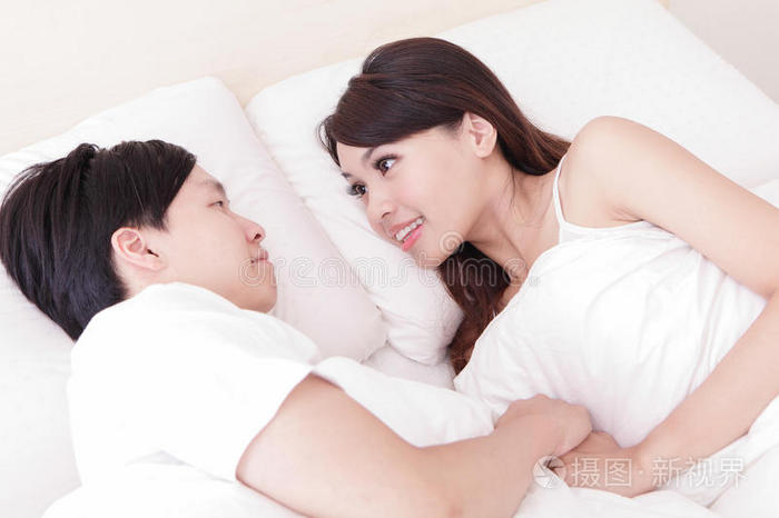 夫妻俩在床上相望幸福的微笑