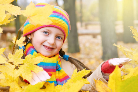 儿童女孩在秋天树叶背景在森林里