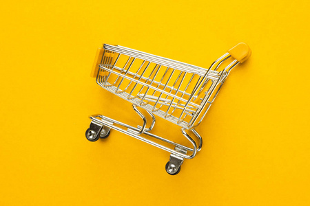 在黄色背景上的购物车照片