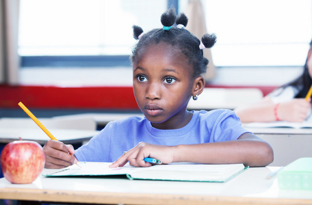 黑人的美国女孩，在小学教室里写她的书