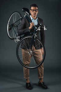 在正式的服装，拿着自行车的商人