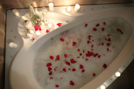 带泡沫和玫瑰花瓣的浴缸照片