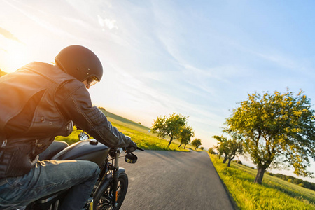 高功率摩托车骑在日落的黑 motorbiker