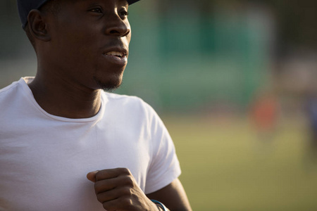 非洲男运动员在体育场跑道上运行的一顶帽子，他训练耐力