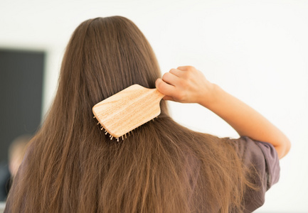 女人梳理头发桑拿和浴室配件一套木制梳子上木制的背景年轻漂亮的女孩