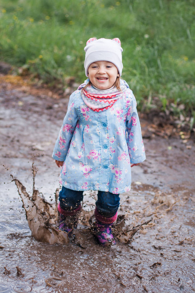 在水坑里跳的小女孩