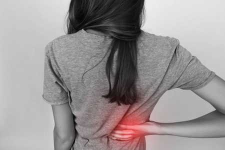 漂亮的女人患背痛.黑色和白色,色的口音.疼痛的概念特写照片