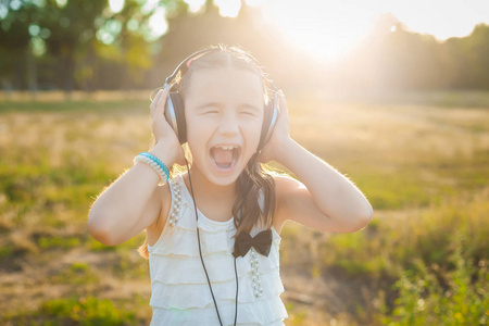 漂亮的女孩戴着耳机听音乐