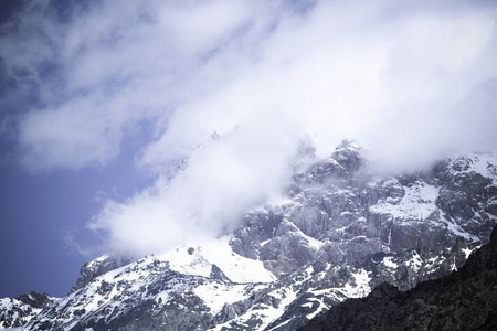 云躺在冰雪覆盖的岩石顶部。景观。吨