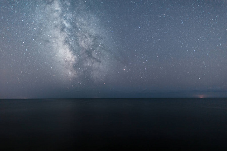 夜晚海与银河系星空的美丽的风景.在海的夜晚天空背景照片