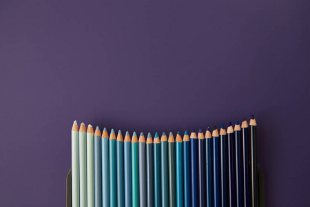 紫色背景上的彩色的铅笔。美丽的组成