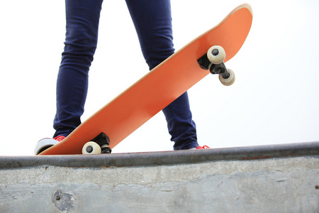 年轻女子双腿滑滑板滑板斜坡