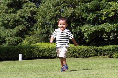夏季在草地 3 岁 上运行的日本男孩