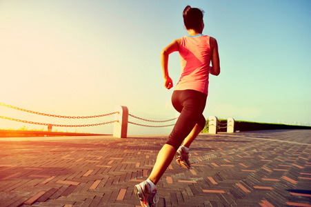 运行在海边的跑步运动员.女人健身剪影日出慢跑锻炼健康概念照片
