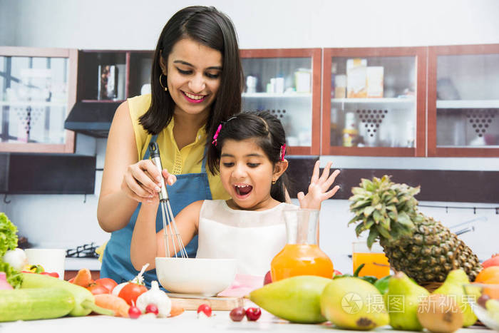 很印度小姐或母亲带着可爱的小女孩儿童或女儿在厨房里开心的新鲜蔬菜和水果是满桌在一起的时间