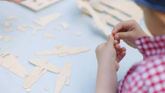 爷爷和他的孙子制作木制飞机在后院在夏季