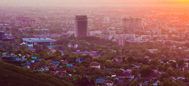 在雾中夕阳与烟雾和粉尘在空气中，哈萨克斯坦的阿拉木图市