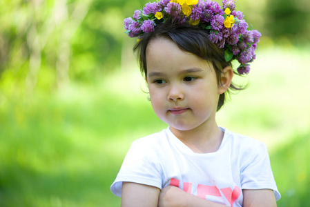 一个开朗的女孩用她的头上的花朵花环的肖像