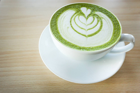 抹茶绿茶拿铁咖啡与心脏形状拿铁艺术在白色杯 o