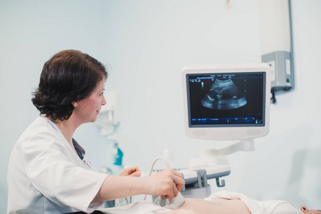 医生显示婴儿超声图像孕妇的计算机上