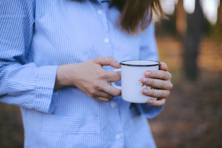 女性旅行者手里拿着杯茶户外活动。冒险